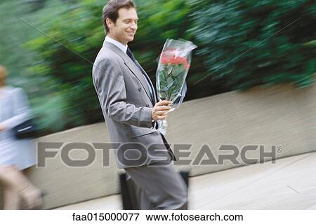 Businessman carrying bouquet of flowers View Large Photo Image Stock Photo - Businessman carrying bouquet of flowers. Fotosearch