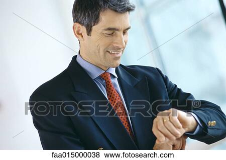 Stock Photo - Businessman, looking at wrist. Fotosearch