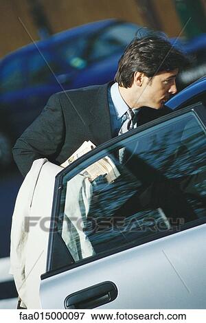 Businessman standing by open car door View Large Photo Image Stock Photo - Businessman standing by open car door. Fotosearch