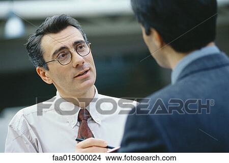 Businessmen talking face to face, head and shoulders View Large Photo Image Picture - Businessmen talking face to face, head and shoulders. Fotosearch