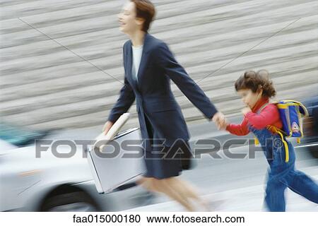 Businesswoman hurrying, holding little boy's hand View Large Photo Image Stock Image - Businesswoman hurrying, holding little boy's hand. Fotosearch