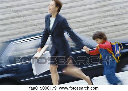 Businesswoman hurrying, holding little boy's hand View Large Photo Image Stock Photo - Businesswoman hurrying, holding little boy's hand. Fotosearch