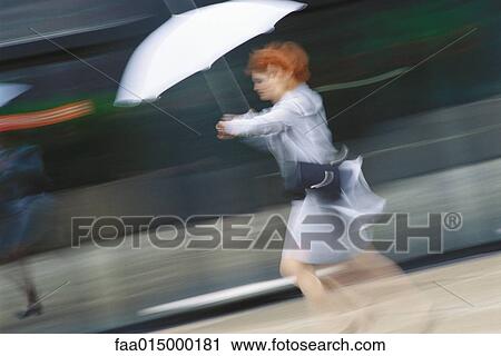 Businesswoman hurrying with umbrella View Large Photo Image Stock Image - Businesswoman hurrying with umbrella. Fotosearch