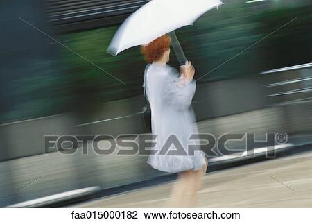 Businesswoman hurrying with umbrella View Large Photo Image Stock Image - Businesswoman hurrying with umbrella. Fotosearch