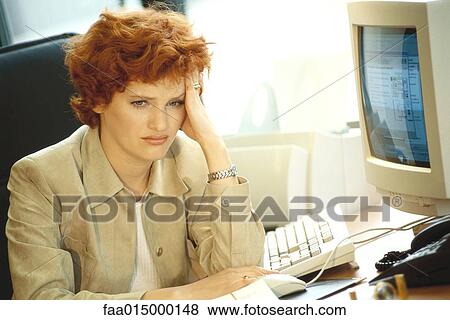 Businesswoman sitting at desk, holding head View Large Photo Image Stock Photo - Businesswoman sitting at desk, holding head. Fotosearch