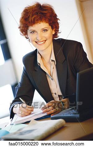 Businesswoman sitting at desk, portrait View Large Photo Image Stock Image - Businesswoman sitting at desk, portrait. Fotosearch