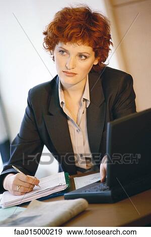 Businesswoman sitting at desk, portrait View Large Photo Image Stock Photo - Businesswoman sitting at desk, portrait. Fotosearch
