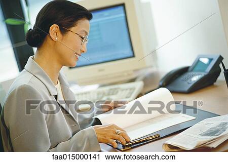 Businesswoman sitting at desk View Large Photo Image Stock Image - Businesswoman sitting at desk. Fotosearch
