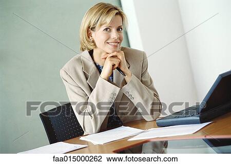 Businesswoman sitting at desk View Large Photo Image Stock Image - Businesswoman sitting at desk. Fotosearch