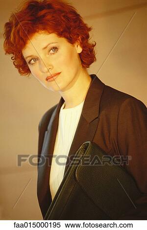 Stock Photography - Businesswoman standing with briefcase underarm, portrait. Fotosearch