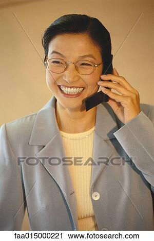 Businesswoman using cell phone, smiling View Large Photo Image Stock Image - Businesswoman using cell phone, smiling. Fotosearch