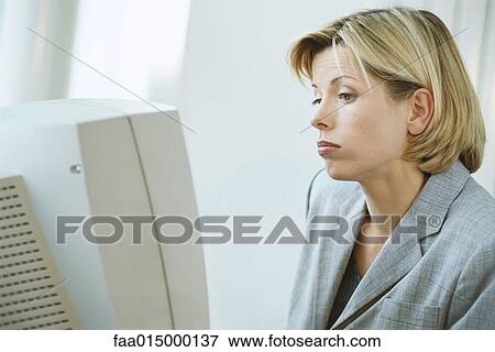 Businesswoman using desktop computer, frowning View Large Photo Image Stock Photo - Businesswoman using desktop computer, frowning. Fotosearch
