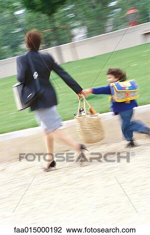 Businesswoman walking with son, blurred motion View Large Photo Image Stock Image - Businesswoman walking with son, blurred motion. Fotosearch