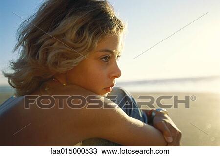 Girl sitting on beach, looking toward ocean, close-up View Large Photo Image Stock Image - Girl sitting on beach, looking toward ocean, close-up. Fotosearch