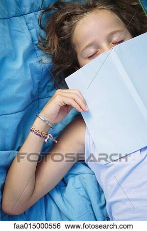Stock Photograph - Girl sleeping with book over face. Fotosearch