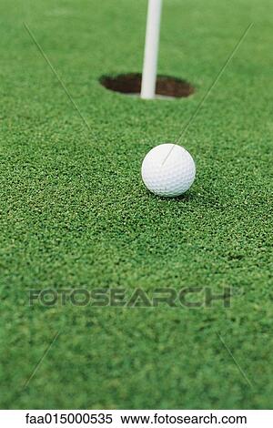 Golf ball on turf near hole, close-up View Large Photo Image Stock Photography - Golf ball on turf near hole, close-up. Fotosearch