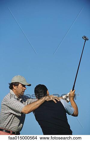 Golf instructor positioning client View Large Photo Image Picture - Golf instructor positioning client. Fotosearch
