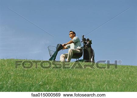 Golfer driving electric golf caddy View Large Photo Image Stock Photo - Golfer driving electric golf caddy. Fotosearch