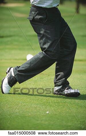 Golfer in mid swing, low section View Large Photo Image Stock Photo - Golfer in mid swing, low section. Fotosearch