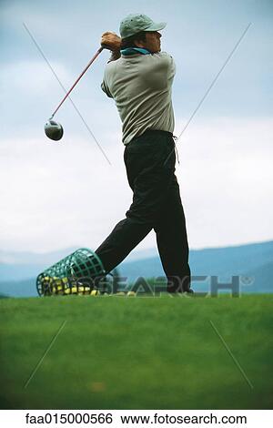 Golfer practicing on driving range, low angle view View Large Photo Image Stock Photograph - Golfer practicing on driving range, low angle view. Fotosearch