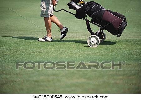 Golfer pulling caddy View Large Photo Image Stock Photography - Golfer pulling caddy. Fotosearch