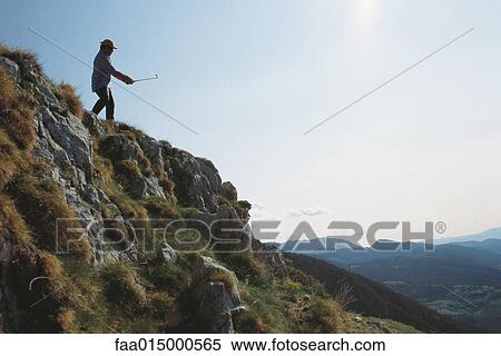 Golfer standing in craggy landscape View Large Photo Image Stock Photography - Golfer standing in craggy landscape. Fotosearch