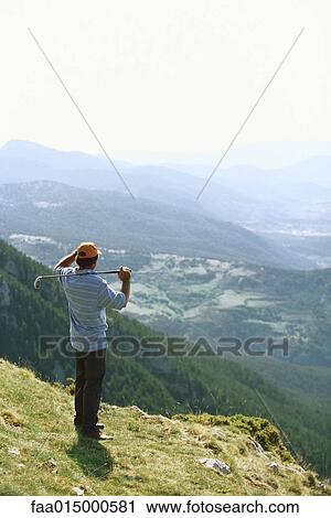 Golfer standing, overlooking mountainous landscape View Large Photo Image Stock Image - Golfer standing, overlooking mountainous landscape. Fotosearch