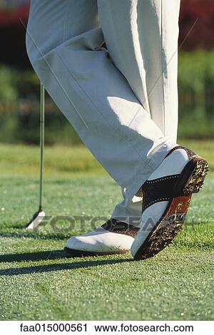 Golfer standing with ankles crossed, knee down View Large Photo Image Stock Image - Golfer standing with ankles crossed, knee down. Fotosearch