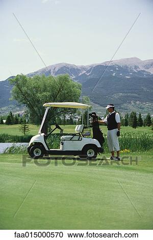 Golfer taking golf bag from golf cart View Large Photo Image Stock Image - Golfer taking golf bag from golf cart. Fotosearch