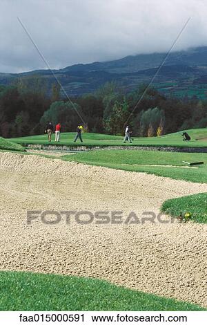 Golfers on golf course, sand trap in foreground View Large Photo Image Stock Image - Golfers on golf course, sand trap in foreground. Fotosearch