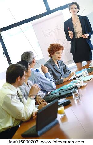 Group of businesspeople sitting around conference table during presentation View Large Photo Image Stock Photo - Group of businesspeople sitting around conference table during presentation. Fotosearch