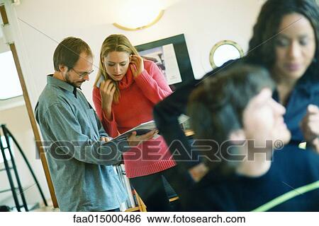Man and woman looking at catalog, second man and woman in foreground View Large Photo Image Stock Photograph - Man and woman looking at catalog, second man and woman in foreground. Fotosearch