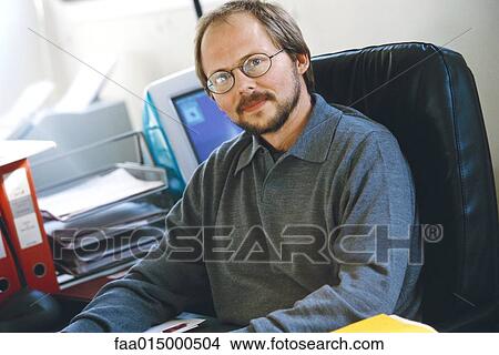 Picture - Man sitting in office, portrait. Fotosearch
