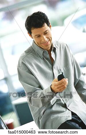 Man using cell phone, smiling View Large Photo Image Stock Image - Man using cell phone, smiling. Fotosearch