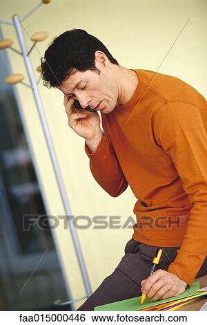 Man using cell phone, taking down note View Large Photo Image Stock Photograph - Man using cell phone, taking down note. Fotosearch