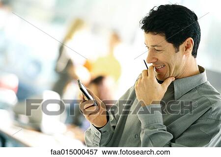 Man using electronic organizer, side view View Large Photo Image Stock Photo - Man using electronic organizer, side view. Fotosearch