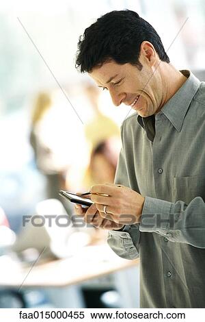 Man using electronic organizer, side view View Large Photo Image Stock Photography - Man using electronic organizer, side view. Fotosearch