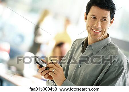 Man using electronic organizer, smiling View Large Photo Image Stock Photo - Man using electronic organizer, smiling. Fotosearch