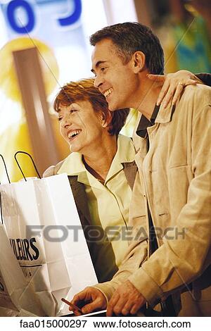 Mature couple making purchase in shop View Large Photo Image Stock Photo - Mature couple making purchase in shop. Fotosearch