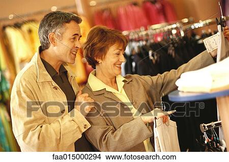 Mature couple shopping in clothing store View Large Photo Image Picture - Mature couple shopping in clothing store. Fotosearch