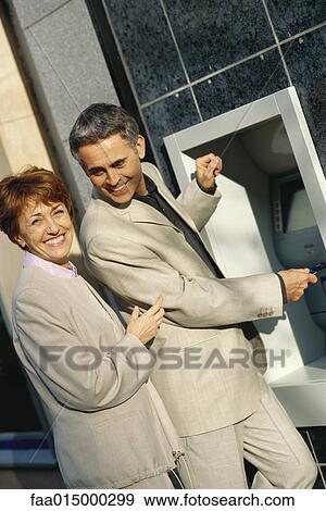 Mature couple standing at ATM machine View Large Photo Image Stock Photo - Mature couple standing at ATM machine. Fotosearch