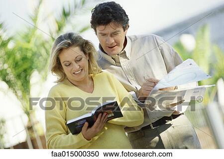 Mature couple standing outdoors with map and guidebook View Large Photo Image Stock Image - Mature couple standing outdoors with map and guidebook. Fotosearch