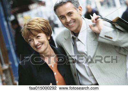 Mature couple walking on city sidewalk View Large Photo Image Stock Image - Mature couple walking on city sidewalk. Fotosearch