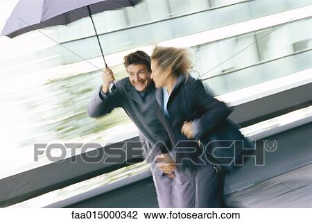 Mature couple walking under umbrella View Large Photo Image Stock Image - Mature couple walking under umbrella. Fotosearch