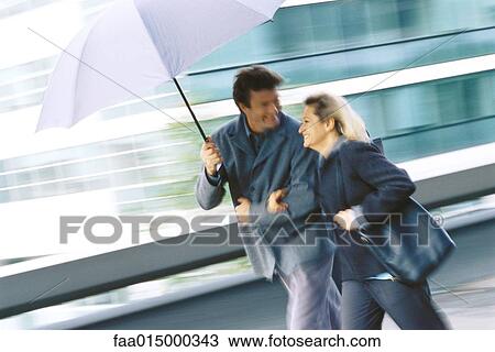 Mature couple walking under umbrella View Large Photo Image Stock Image - Mature couple walking under umbrella. Fotosearch