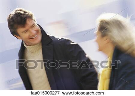 Stock Photo - Middle aged couple walking, blurred motion. Fotosearch