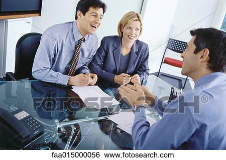 Professional couple having meeting with businessman, discussing documents View Large Photo Image Stock Photograph - Professional couple having meeting with businessman, discussing documents. Fotosearch