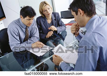 Professional couple having meeting with businessman, discussing documents View Large Photo Image Stock Photography - Professional couple having meeting with businessman, discussing documents. Fotosearch