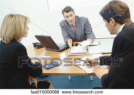 Professional couple sitting in meeting with sales executive View Large Photo Image Stock Photo - Professional couple sitting in meeting with sales executive. Fotosearch