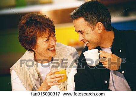 Senior couple holding up glass of juice and mug View Large Photo Image Stock Photo - Senior couple holding up glass of juice and mug. Fotosearch